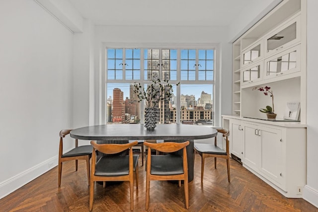 dining space with dark parquet floors and built in shelves