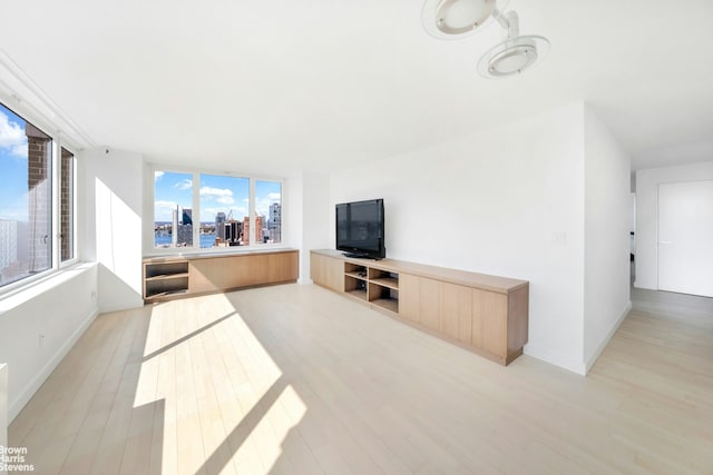 living area with light wood-style floors and baseboards