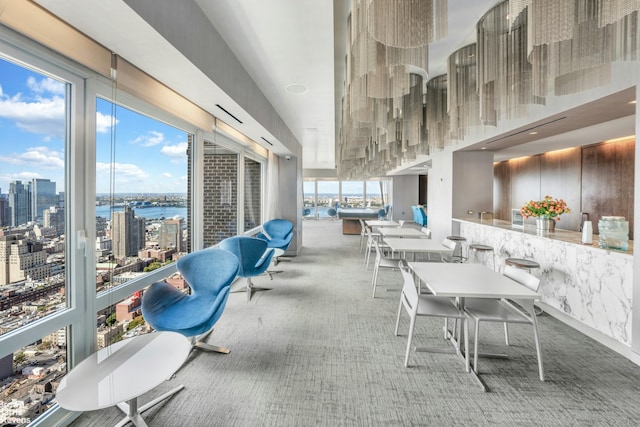 carpeted dining room featuring a water view and a city view