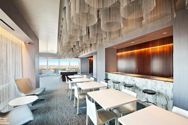 carpeted dining room with a towering ceiling