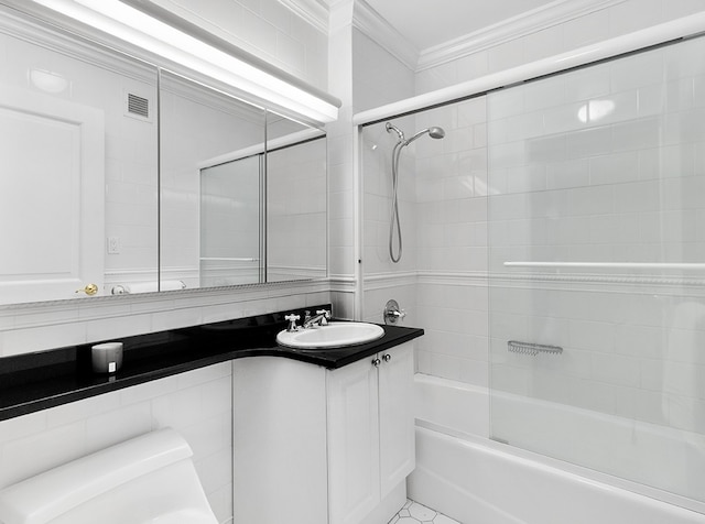 bathroom with ornamental molding, enclosed tub / shower combo, visible vents, and vanity