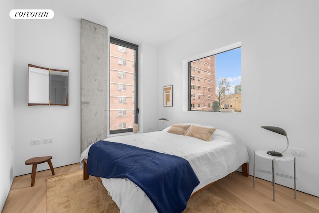 bedroom featuring multiple windows and hardwood / wood-style flooring