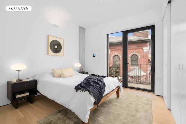 bedroom with access to outside, visible vents, and light wood-style floors