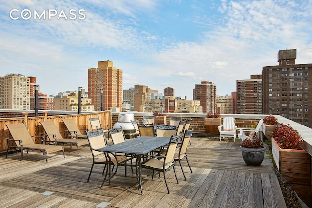 deck with a skyline view and outdoor dining space