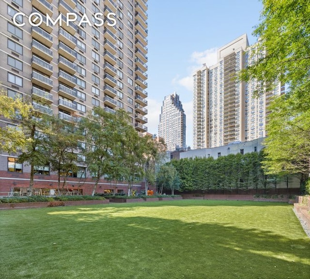 view of community featuring a city view and a lawn