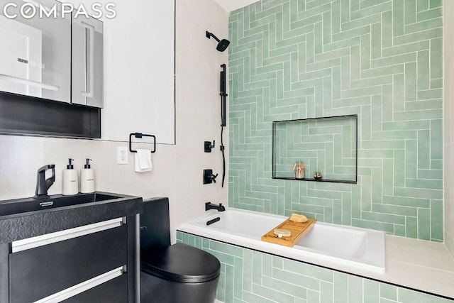 bathroom featuring tasteful backsplash, tiled shower / bath, and vanity