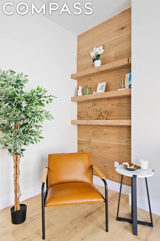 living area with wood-type flooring and wood walls