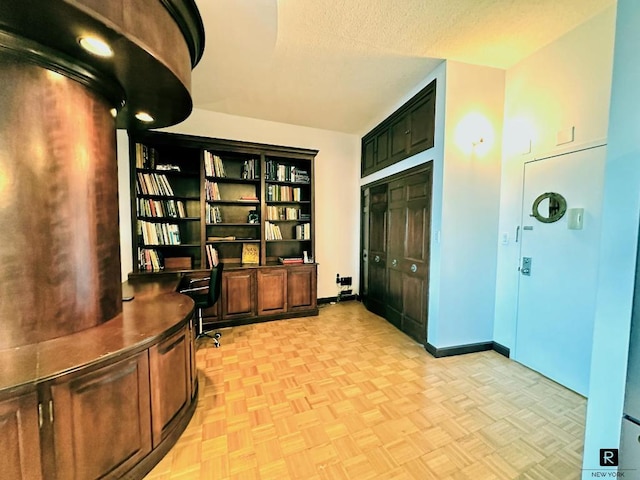 office area featuring light parquet flooring and a textured ceiling