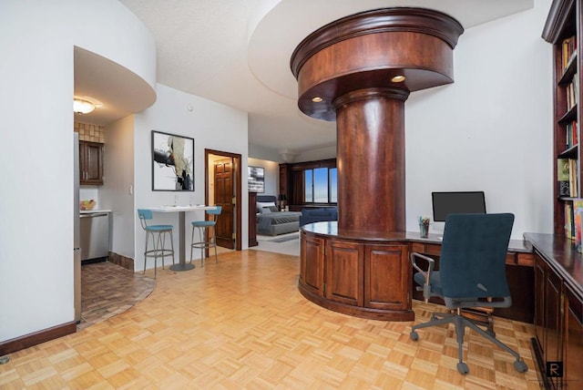 home office featuring decorative columns and light parquet floors