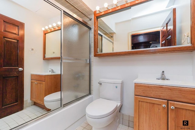 full bathroom with bath / shower combo with glass door, vanity, toilet, and tile patterned floors