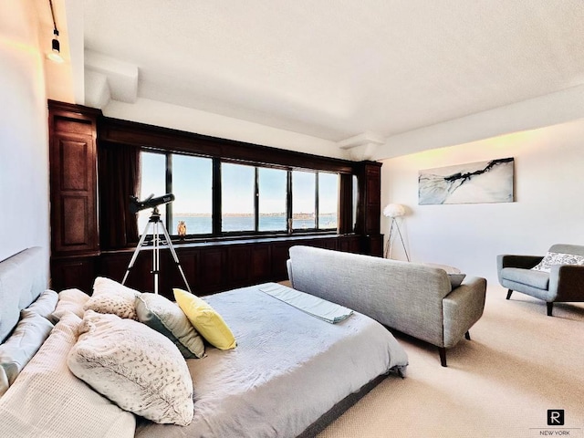 bedroom with a water view and carpet floors