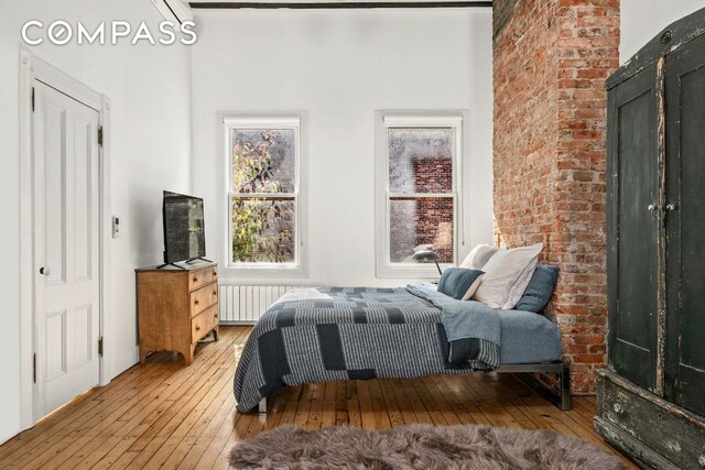 unfurnished dining area with sink, dark wood-type flooring, beamed ceiling, and brick wall