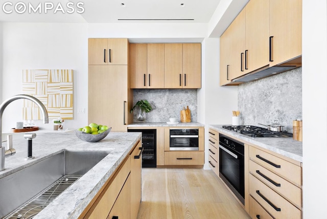 kitchen featuring tasteful backsplash, oven, sink, and light brown cabinets