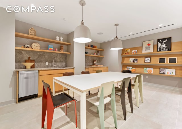 kitchen featuring open shelves, a sink, hanging light fixtures, stainless steel dishwasher, and tasteful backsplash