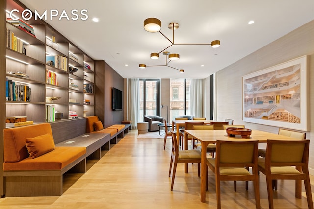 dining room with recessed lighting, floor to ceiling windows, light wood-type flooring, and an inviting chandelier