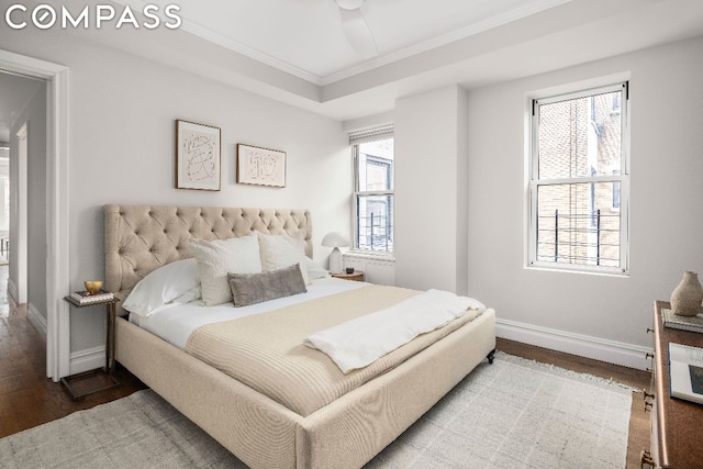 bedroom featuring ceiling fan, multiple windows, ornamental molding, and hardwood / wood-style floors