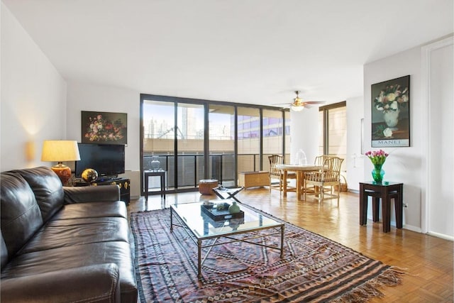 living room with parquet floors, a wall of windows, and ceiling fan