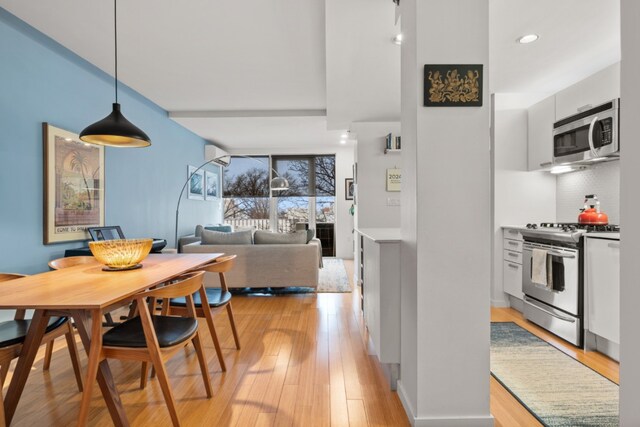 dining area featuring light hardwood / wood-style flooring and a wall mounted AC