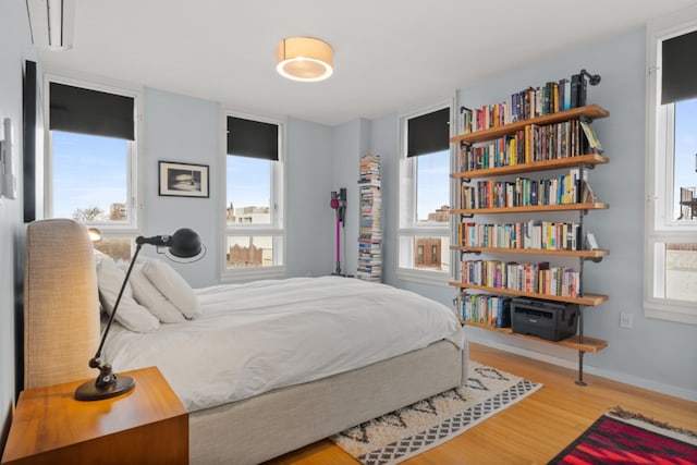 bedroom with hardwood / wood-style floors and multiple windows