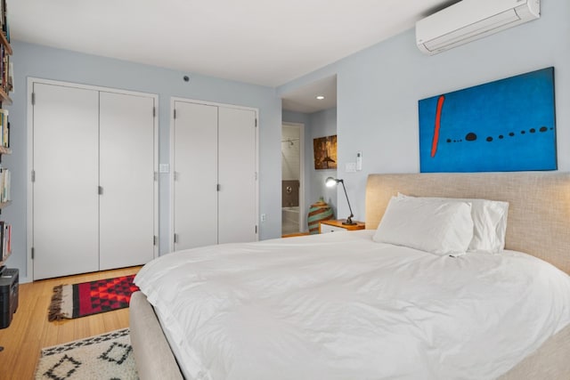 bedroom with wood-type flooring and a wall mounted air conditioner