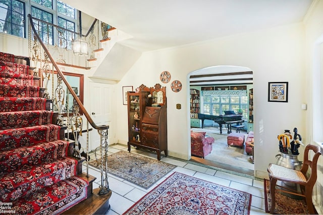 entryway featuring light tile patterned floors, plenty of natural light, and ornamental molding