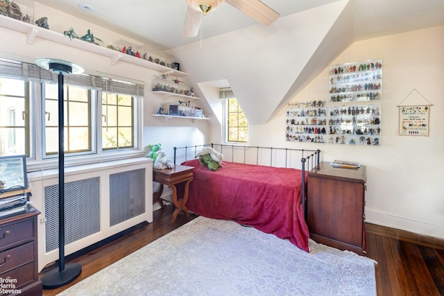 bedroom featuring dark hardwood / wood-style flooring, radiator, and ceiling fan