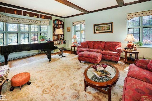 living room with hardwood / wood-style flooring, radiator heating unit, beamed ceiling, and a healthy amount of sunlight