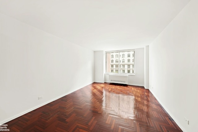 spare room with parquet flooring and radiator heating unit