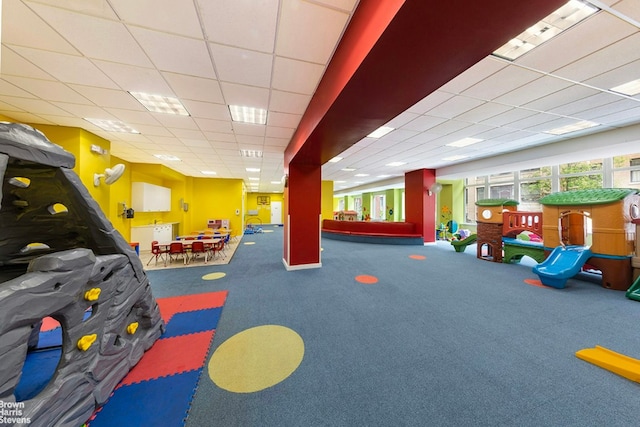 recreation room featuring carpet floors and a drop ceiling