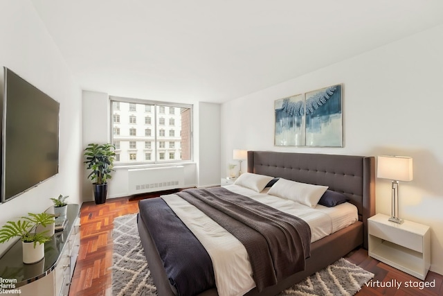 bedroom with parquet floors and radiator heating unit