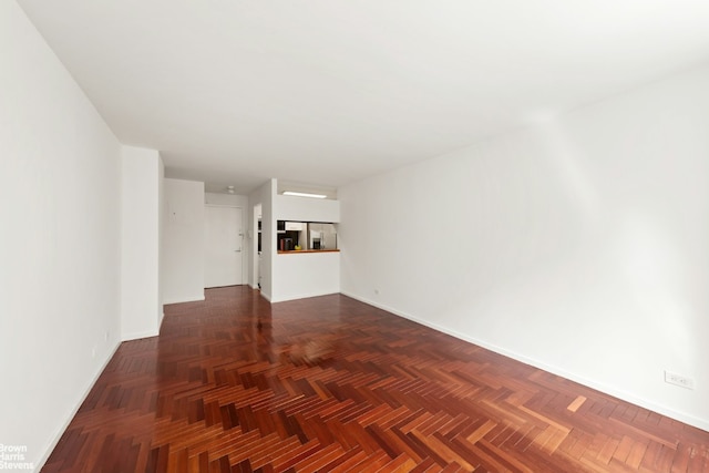 unfurnished living room with dark parquet floors