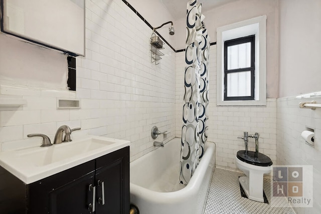 bathroom featuring toilet, tile patterned floors, shower / bath combination with curtain, vanity, and tile walls