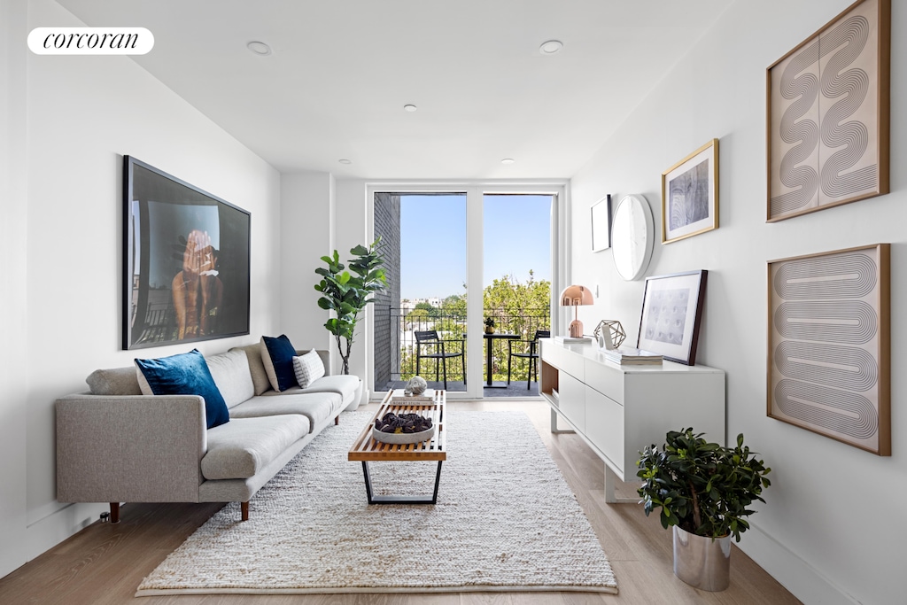 living area featuring light wood finished floors, a wall of windows, and visible vents