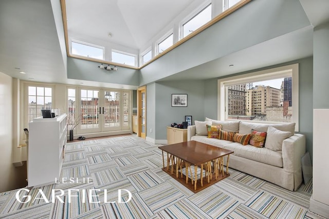 carpeted living room with french doors and a towering ceiling