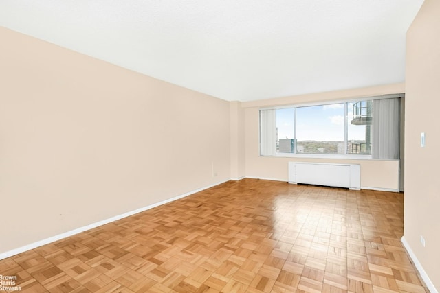 spare room with light parquet flooring and radiator heating unit