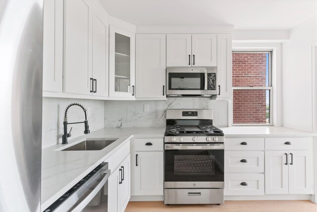 1655 Flatbush Ave Unit B1806, New York City, NY 11210 - kitchen featuring stainless steel appliances, white cabinets, backsplash, and glass insert cabinets