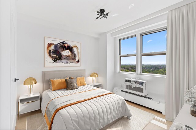 1655 Flatbush Ave Unit B1806, New York City, NY 11210 - bedroom with light wood finished floors, a baseboard heating unit, and a wall mounted air conditioner