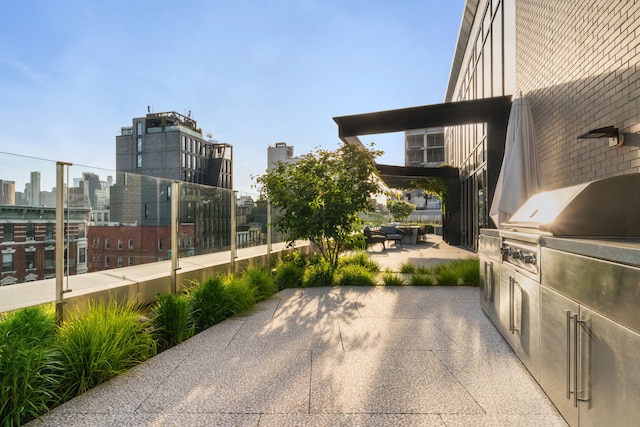 view of patio / terrace with a view of city, grilling area, and exterior kitchen