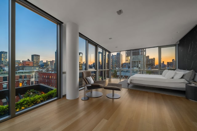 bedroom with a wall of windows and wood-type flooring