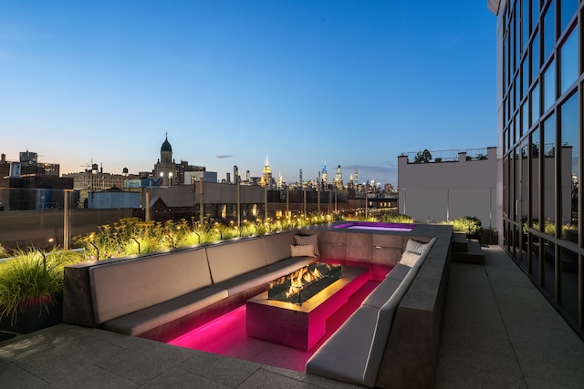 view of patio with an outdoor fire pit and a city view