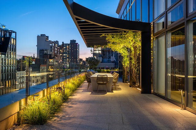 patio terrace at dusk featuring a view of city