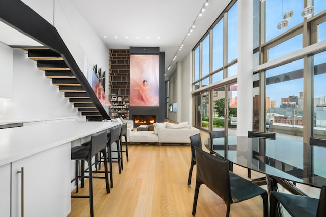 dining area featuring a high ceiling and light wood-type flooring