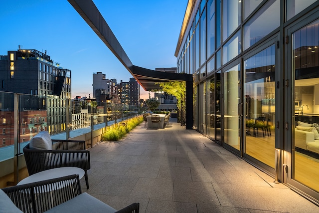 patio terrace at dusk featuring a view of city