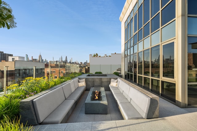 view of patio with a view of city and an outdoor living space with a fire pit