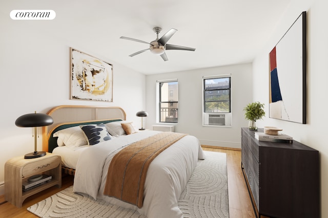 bedroom featuring light wood finished floors, visible vents, ceiling fan, cooling unit, and baseboards