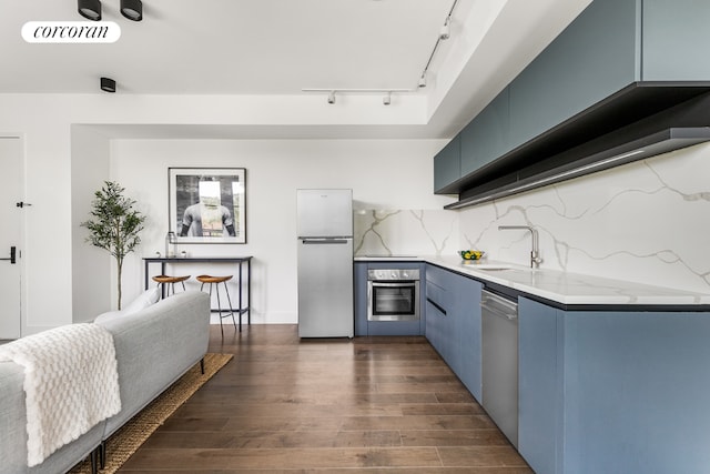 kitchen featuring dark wood-type flooring, appliances with stainless steel finishes, blue cabinets, and sink