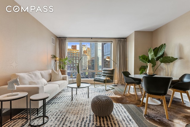 living room with a view of city, visible vents, and wood finished floors