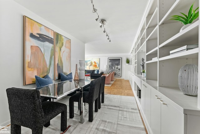 dining space featuring light parquet floors and rail lighting