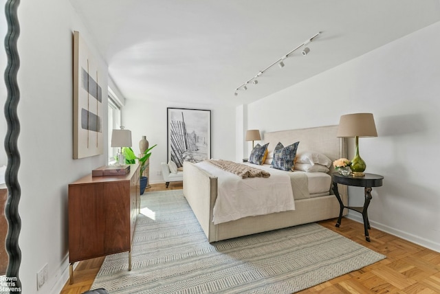 bedroom featuring light parquet flooring and rail lighting