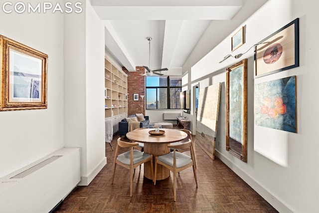 dining area featuring ceiling fan, beam ceiling, dark parquet flooring, and built in shelves